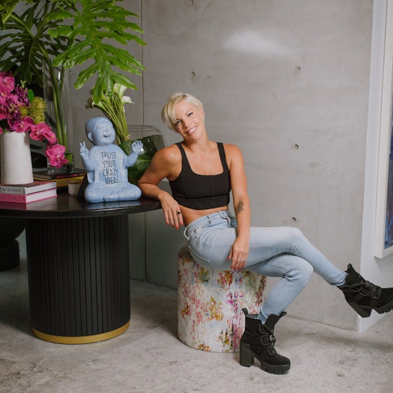 Anne Mahlum, the Founder and former CEO of Solidcore is shown seated at a table smiling at the viewer.