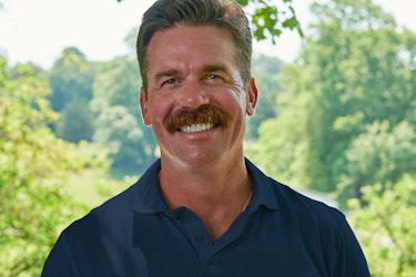  A smiling headshot of Gregory Vetter, former Founder of Tessemae and Founder of Alta Fresh Foods, standing outside with trees in the background. Gregory has brown hair and a thick mustache, and he's wearing a dark blue polo shirt. 