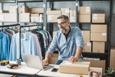  Man working at his small business shipping clothing packages. 